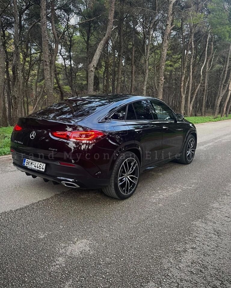 A scenic landscape featuring rolling hills under a clear blue sky, with vibrant green grass and a few scattered wildflowers in the foreground.